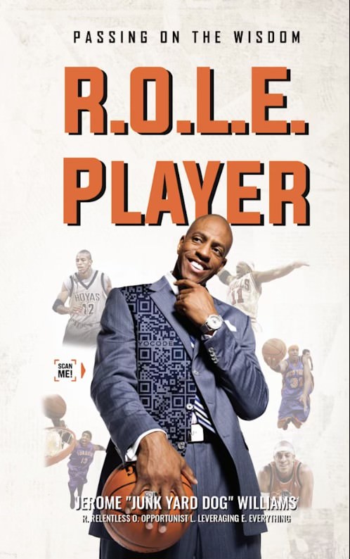 Jerome Williams holding his book "R.O.L.E. Player: Passing on the Wisdom"